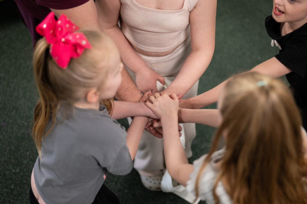 A photo of five people from our funded partner, Re:establish, joining hands on top of each other. 