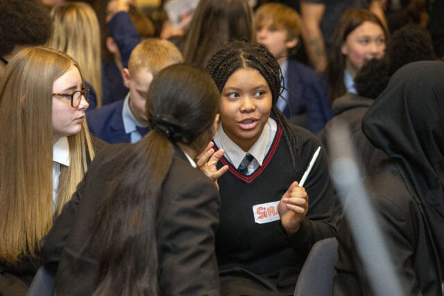 Girls in school uniforms speaking to each other