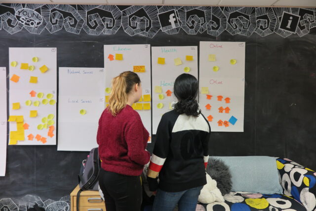 Two young people standing in front of a board