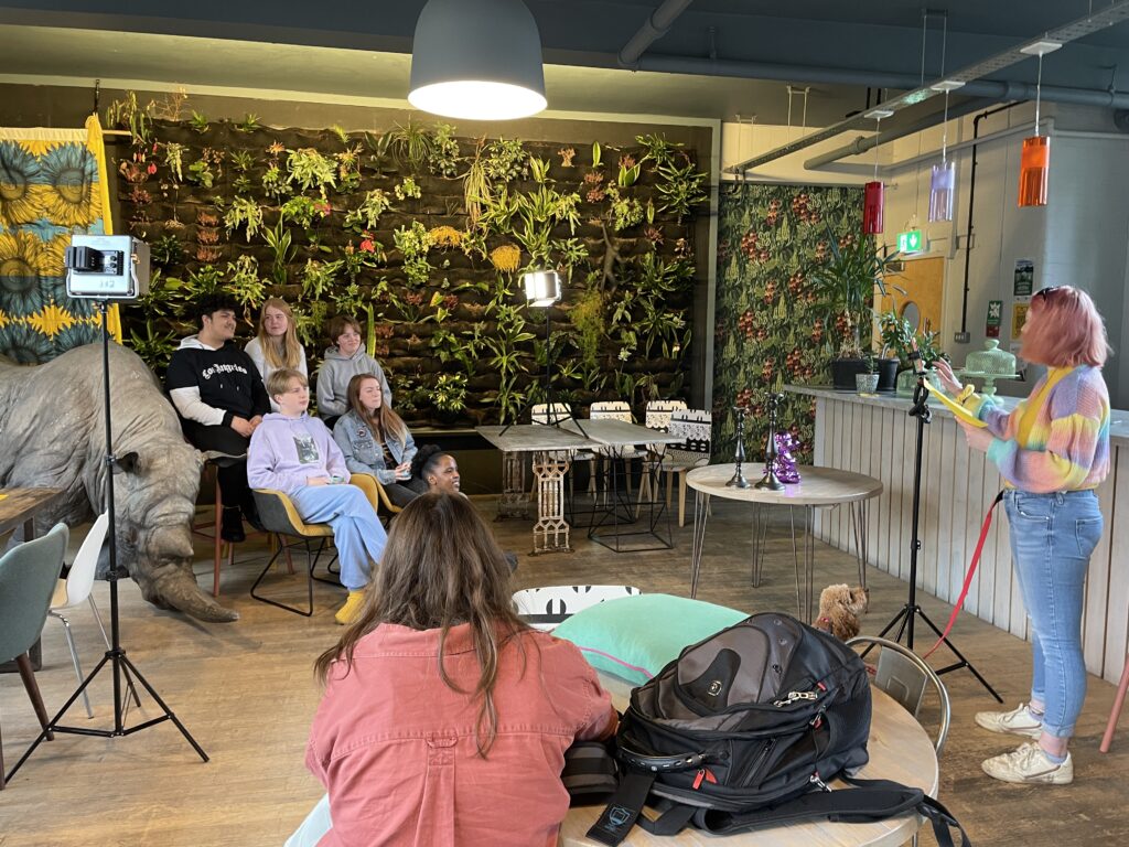 A group of young people looking at another young person who is sharing what they've learned from being involved in the campaign