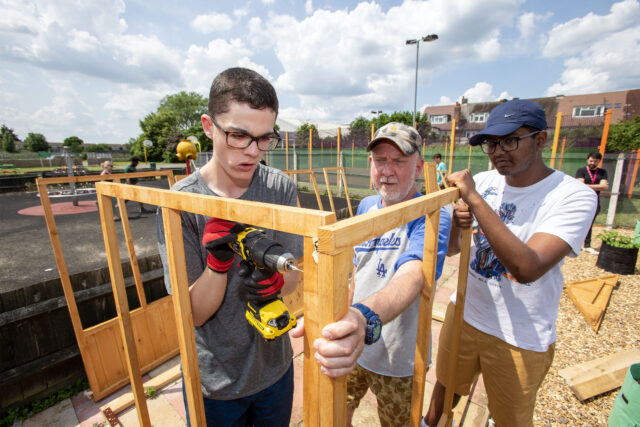 Young people building a frame outdoors