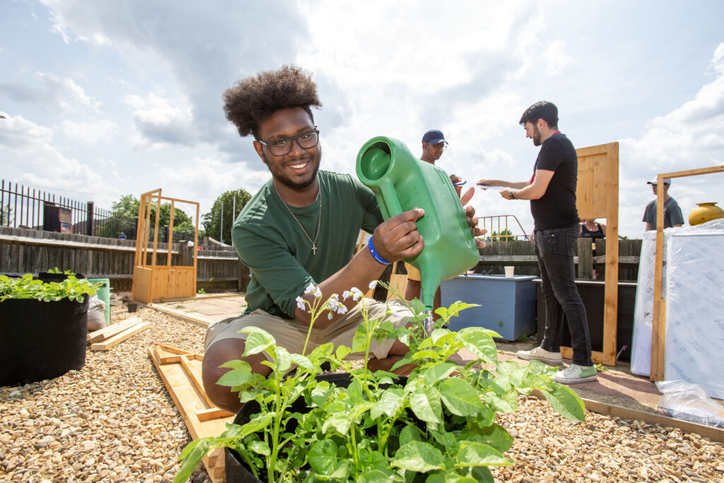 Young man watering a plant