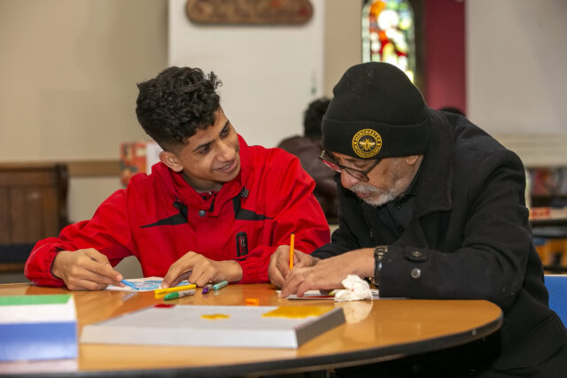 Two people drawing and in conversation