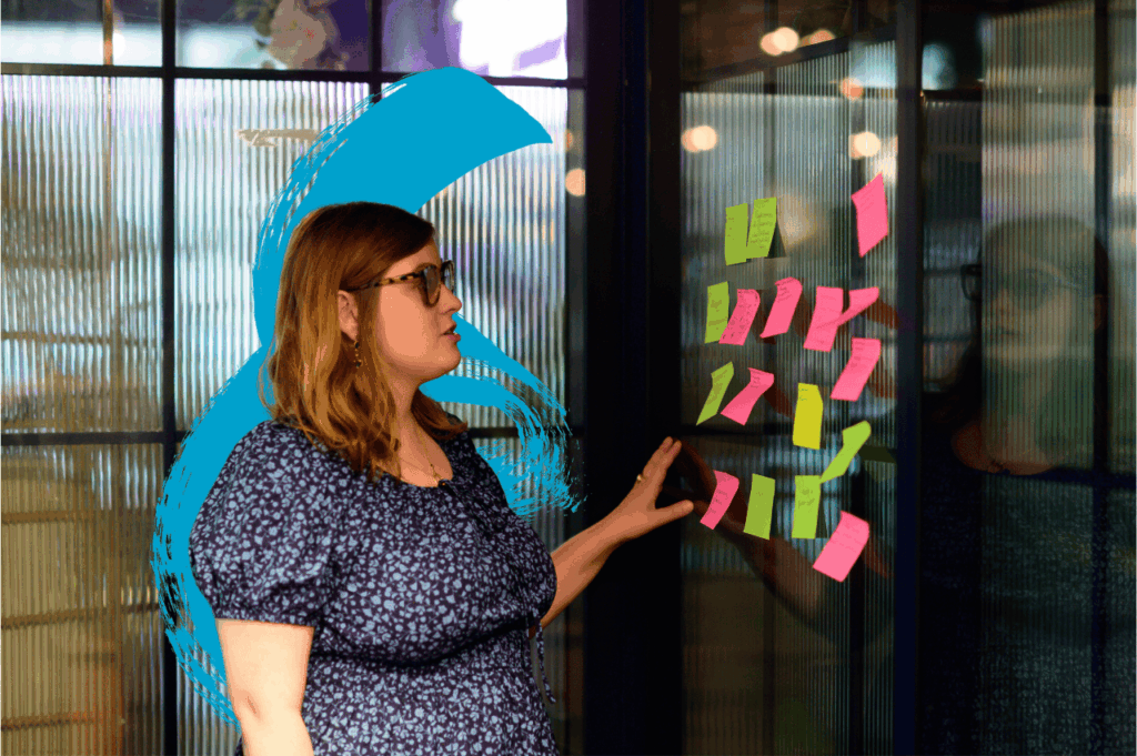 Young woman reading post it notes on a wall
