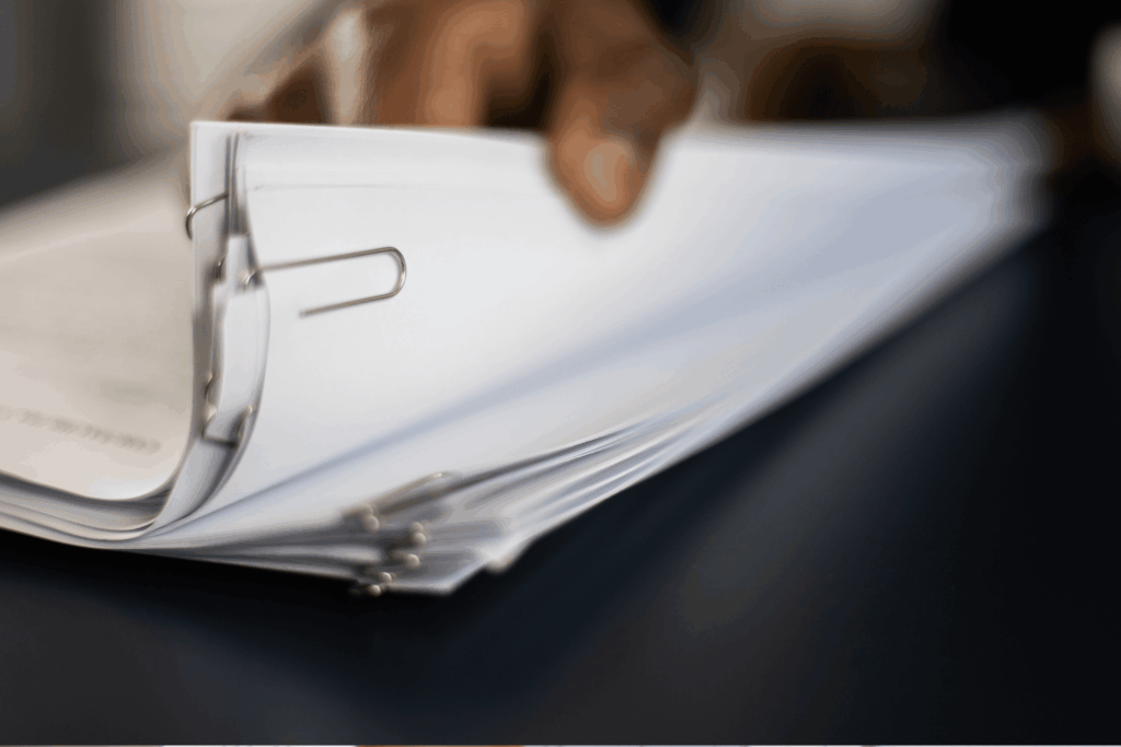 A person's hand flicking through papers.